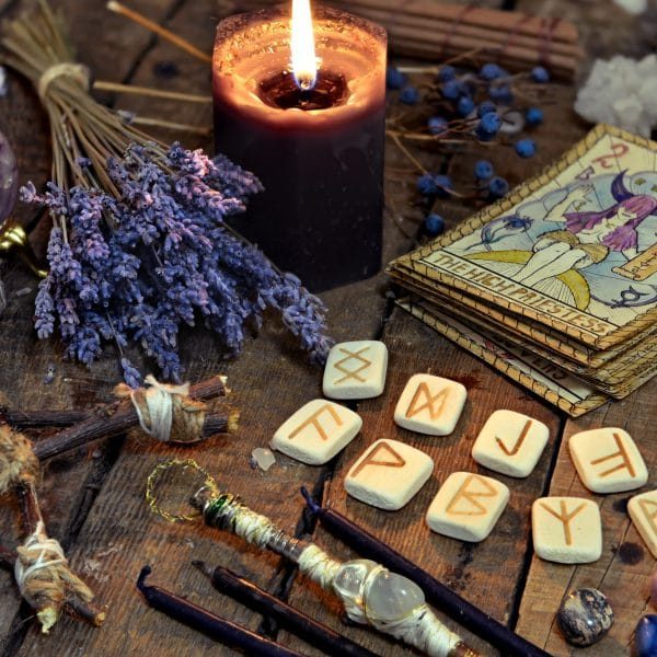 Tarot cards, ancient runes, black candle and pentagram. Occult, esoteric, divination and wicca concept. Mystic and vintage background